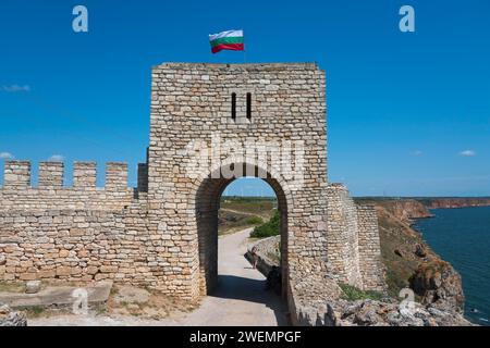 Steinbogen einer alten Festung mit schwenkender Flagge neben einer steilen Klippe, Festungsruinen, Kap Kaliakra, Dobruja, Schwarzes Meer, Bulgarien Stockfoto