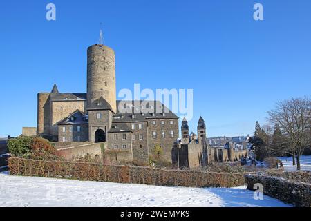 Schloss Genoveva im 13. Jahrhundert mit Donjon Goloturm und neoromanischer Herz-Jesu-Kirche aus dem Jahr 1911 mit Zwillingstürmen im Winter mit Schnee Stockfoto