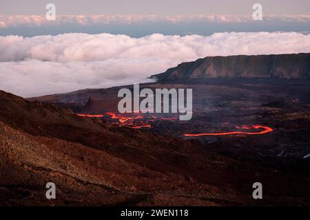 Ein fesselnder Blick auf den Vulkan Piton de la Fournaise auf der Insel Reunion, der den beeindruckenden Lavastrom im Vordergrund zeigt. Stockfoto