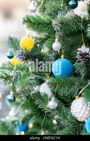 Weihnachtsbaum mit blauen und gelben Dekorationen in den Farben der ukrainischen Flagge. Nahaufnahme Stockfoto