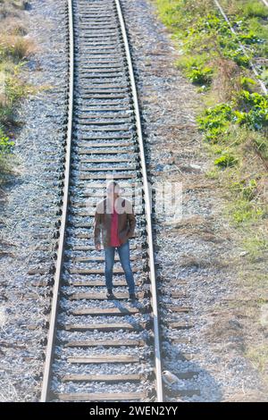 Einsamer Mann, der auf Eisenbahngleisen steht Stockfoto