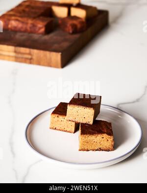 Süßes Frühstück. Blondies Bars auf weißem Teller, heller Hintergrund luftiges Mood Food Foto Stockfoto