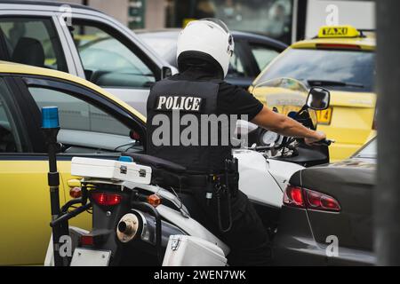 Ein griechischer Polizist auf einem Motorrad steht in einem Stau. Hochwertige Fotos Stockfoto