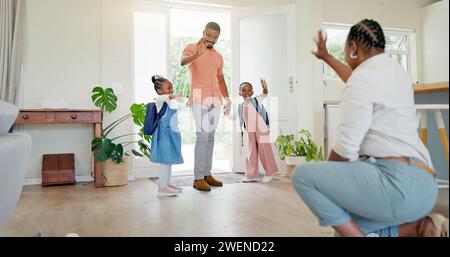 Schwarze Familie, Mutter und winken Kindern zu, die mit Liebe, Sorgfalt oder Zuneigung zur Schule gehen. Auf Wiedersehen, Eltern und Mädchen verlassen das Haus zum Kindergarten Stockfoto