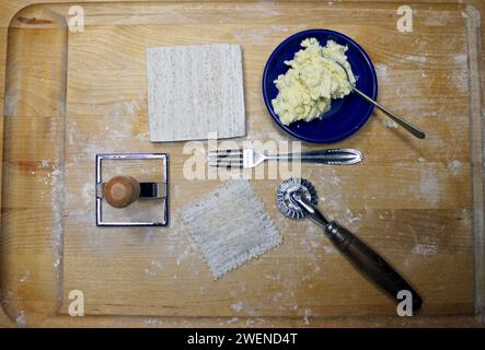 Hausgemachte Revioli über dem Kopf von Werkzeugen und Ricotta-Käse. Flache Lagen Stockfoto