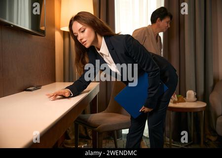 Manager überwacht die Leistung des Zimmermädchens während der Zimmerreinigung Stockfoto