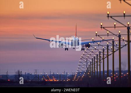 Das Passagierflugzeug landet während eines wunderbaren Sonnenuntergangs. Stockfoto