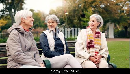 Senioren, Frauen und Freunde, die in den Park zeigen, mit Aussicht und einem Pensionierungslächeln in einem Garten. Natur, Urlaub und Gespräch mit älteren Frauen auf Stockfoto