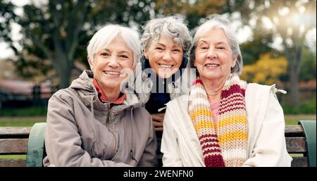 Senioren, sitzende Frauen und Freunde stehen im Park mit einem Pensionslächeln im Garten gegenüber. Natur, Porträt und Umarmung mit älteren Frauen im Urlaub in Stockfoto