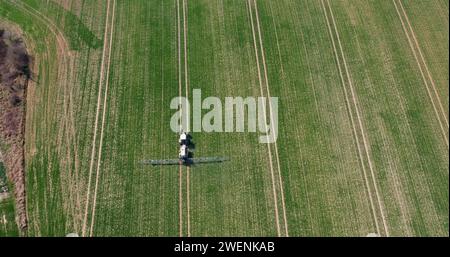 Traktor sprüht Pestizide auf Kulturen auf dem Landwirtschaftsfeld Stockfoto