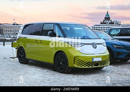 2023 Volkswagen VW ID. Buzz Elektrobus, der an einem Wintertag am öffentlichen Ladehafen am Meer die Batterie auflädt. Helsinki, Finnland. Dezember 2023. Stockfoto