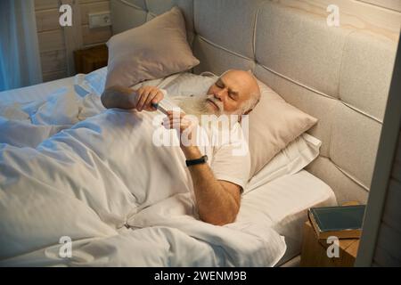 Der alte Mann leidet an Erkältung und Kopfschmerzen Stockfoto