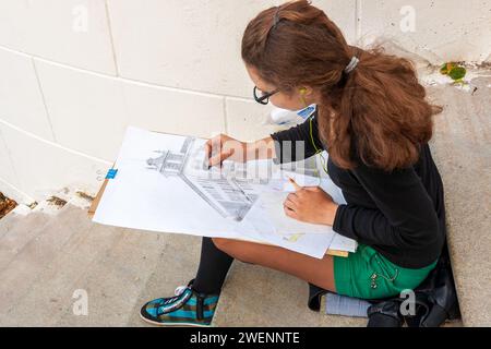 Minsk, Weißrussland - 15. Juni 2014: Der Künstler arbeitet an der Plein Air. Ein Mädchen zeichnet ein Gebäude auf der Straße. Blick von oben Stockfoto