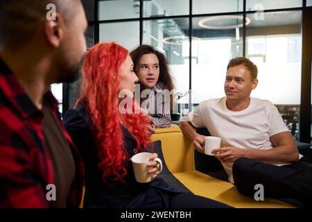 Büroangestellte tratschen während der Kaffeepause in der Bürohalle Stockfoto