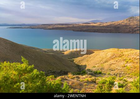 Cody, Wyoming, USA – Blick auf den Shoshone River und das Reservoir, das von den Ausläufern der Rockies am Horizont bei Sonnenaufgang in Cody, USA, flankiert wird. Stockfoto