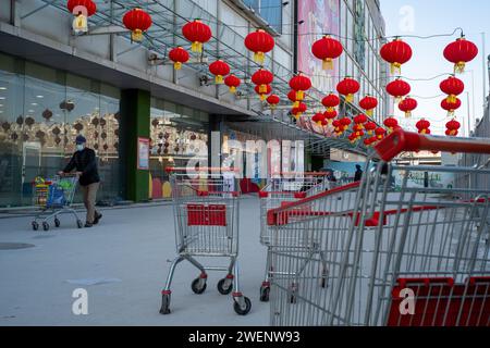 Die Verbraucher verlassen ein mit roten Laternen dekoriertes Einkaufszentrum nach dem Einkaufen, während das chinesische Frühlingsfest in Peking naht. 01-Jan-2024 Stockfoto