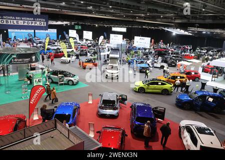 Erfurt, Deutschland. Januar 2024. Besucher stehen zwischen Autos in einer Ausstellungshalle der Automobil Messe Erfurt. Insgesamt 130 Aussteller zeigen in drei Messehallen die neuesten Entwicklungen im Automobilmarkt. Quelle: Bodo Schackow/dpa/Alamy Live News Stockfoto