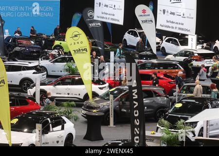 Erfurt, Deutschland. Januar 2024. Besucher stehen zwischen Autos in einer Ausstellungshalle der Automobil Messe Erfurt. Insgesamt 130 Aussteller zeigen in drei Messehallen die neuesten Entwicklungen im Automobilmarkt. Quelle: Bodo Schackow/dpa/Alamy Live News Stockfoto