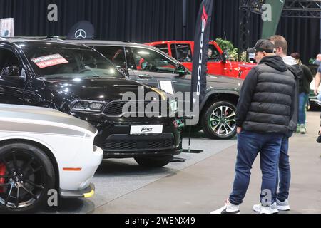 Erfurt, Deutschland. Januar 2024. Besucher stehen zwischen Autos in einer Ausstellungshalle der Automobil Messe Erfurt. Insgesamt 130 Aussteller zeigen in drei Messehallen die neuesten Entwicklungen im Automobilmarkt. Quelle: Bodo Schackow/dpa/Alamy Live News Stockfoto