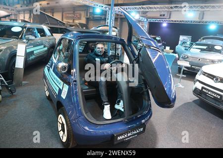 Erfurt, Deutschland. Januar 2024. Ein Mitarbeiter sitzt in einem elektrischen Stadtauto der Marke „Microlino“ in einer Ausstellungshalle der Automobil Messe Erfurt. Insgesamt 130 Aussteller zeigen in drei Messehallen die neuesten Entwicklungen im Automobilmarkt. Quelle: Bodo Schackow/dpa/Alamy Live News Stockfoto