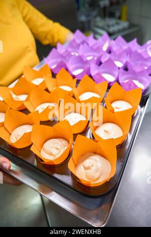 Ein erfahrener Bäcker bereitet sich vor, Muffins zu backen Stockfoto