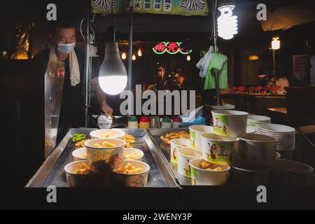 Taipei, Republik China - 1. Oktober 2023: Ein Straßenverkäufer mit frittiertem Huhn auf dem geschäftigen Raohe Street Night Market in Taipei, Taiwan. Stockfoto