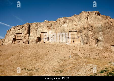 Blick auf die Nekropolis Naqsh-e Rostam, niedriger felsiger Hügel (auch bekannt als Hossein-Berg) mit felsengehauenen Gräbern von Königen der Achämenischen Dynastie in der Nähe von Persepolis, Iran Stockfoto