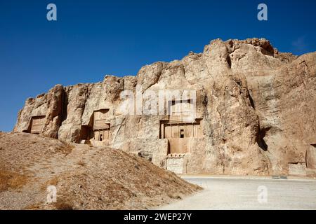 Blick auf die Nekropolis Naqsh-e Rostam, niedriger felsiger Hügel (auch bekannt als Hossein-Berg) mit felsengehauenen Gräbern von Königen der Achämenischen Dynastie in der Nähe von Persepolis, Iran Stockfoto