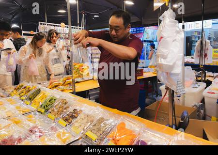 Taipei, Republik China - 1. Oktober 2023: Straßenverkäufer mit getrockneten Früchten auf dem geschäftigen Raohe Street Night Market in Taipei, Taiwan. Stockfoto