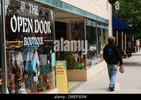 Ein junger Mann läuft an einem Boutique-Geschäft vorbei, das Vintage-Kleidung und Geschenke verkauft, einem von mehreren derartigen Geschäften in Asheville, North Carolina Stockfoto