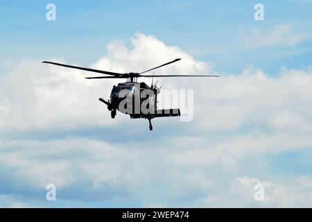 Ein militärischer Hubschrauber mit schwarzem Falken fliegt während des Manövers durch den Himmel Stockfoto