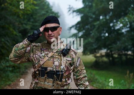 Ein engagierter Soldat grüßt seine Eliteeinheit und zeigt Kameradschaft und Bereitschaft für die gefährlichsten militärischen Operationen Stockfoto