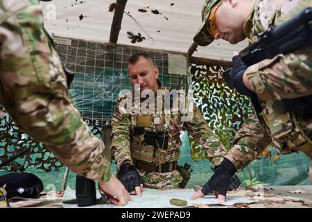 Eine gut ausgebildete Militäreinheit organisiert eine taktische Mission, während sie während einer Besprechung eine Militärkarte studiert Stockfoto