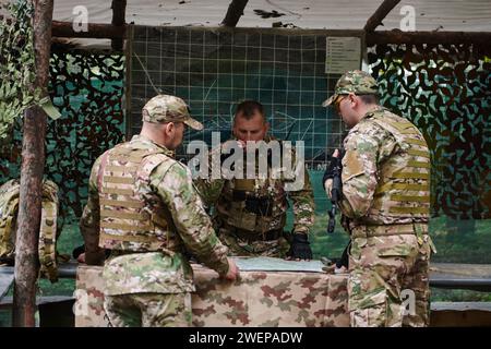 Eine gut ausgebildete Militäreinheit organisiert eine taktische Mission, während sie während einer Besprechung eine Militärkarte studiert Stockfoto