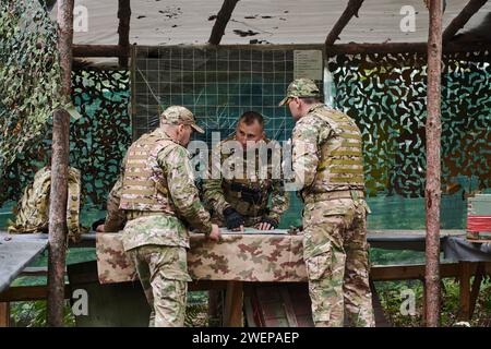 Eine gut ausgebildete Militäreinheit organisiert eine taktische Mission, während sie während einer Besprechung eine Militärkarte studiert Stockfoto