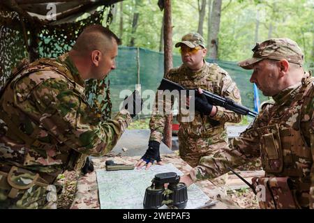 Eine gut ausgebildete Militäreinheit organisiert eine taktische Mission, während sie während einer Besprechung eine Militärkarte studiert Stockfoto