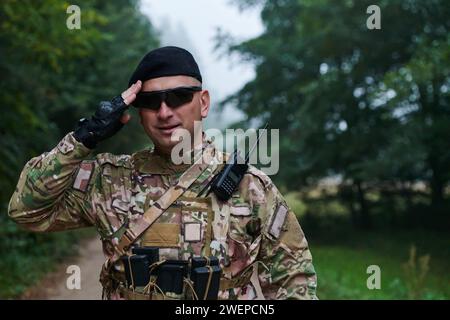 Ein engagierter Soldat grüßt seine Eliteeinheit und zeigt Kameradschaft und Bereitschaft für die gefährlichsten militärischen Operationen Stockfoto