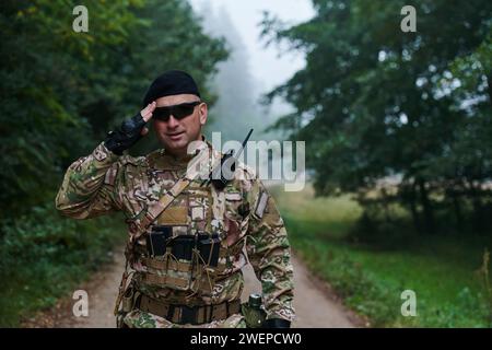 Ein engagierter Soldat grüßt seine Eliteeinheit und zeigt Kameradschaft und Bereitschaft für die gefährlichsten militärischen Operationen Stockfoto