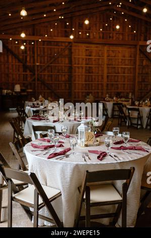Einige Tische und Stühle sind in rustikaler Hochzeitsatmosphäre angeordnet Stockfoto