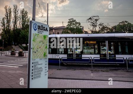Bild einer Straßenbahn, die in den Straßen von riga fährt, betrieben von Rigas satiksme vor einer Karte von riga. Rīgas satiksme ist ein öffentliches Unternehmen in kommunalem Besitz Stockfoto