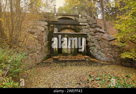 Wunderschöne Natur Herbstlandschaft. Blick auf den Herbst-Stadtpark mit goldgelbem Laub an bewölktem Tag. Spaziergänge im Stadtpark mit herbstlich gefallenen Blättern Stockfoto