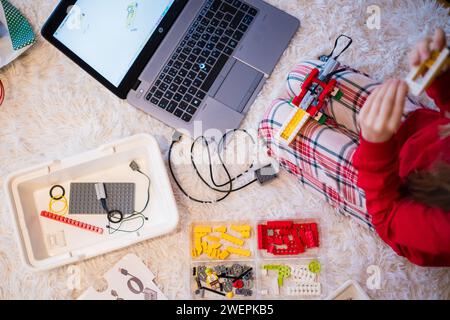 Tallinn, Estland - 25. Dezember 2023: Kind baut einen beweglichen Lego Education WeDo Roboter zu Hause. Stockfoto