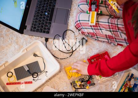 Tallinn, Estland - 25. Dezember 2023: Kind baut einen beweglichen Lego Education WeDo Roboter zu Hause. Stockfoto