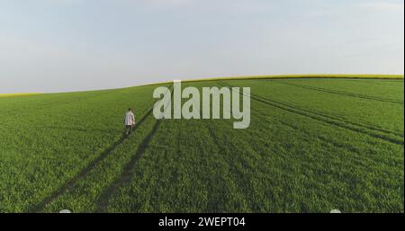 Landwirtschaft, männlicher Landwirt, der mit einem digitalen Tablet über das landwirtschaftliche Feld läuft. Stockfoto