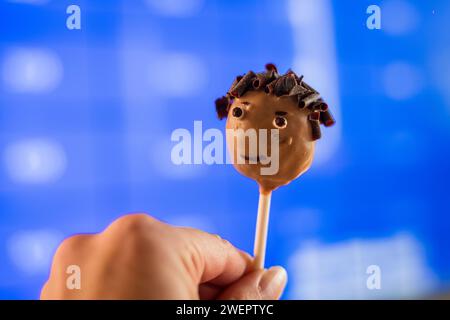 Lustiger Kuchen auf einem Stock mit dem Kopf einer Person. Stockfoto