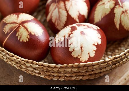 Ostereier gefärbt mit Zwiebelschalen in einem Korb auf einem Tisch, Nahaufnahme Stockfoto