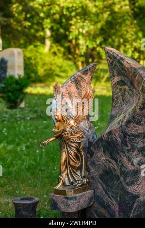 Geschmücktes Grab mit Engelsfigur auf dem Friedhof Stockfoto