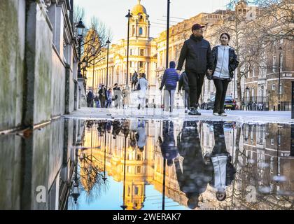 London, Großbritannien. Januar 2024. Fußgänger auf Whitehall spiegeln sich in einer großen Pfütze vom Regen der letzten Nacht. Nach starken Regenschauern über Nacht sah die Hauptstadt bis heute Abend Sonnenschein und klaren Himmel. Quelle: Imageplotter/Alamy Live News Stockfoto