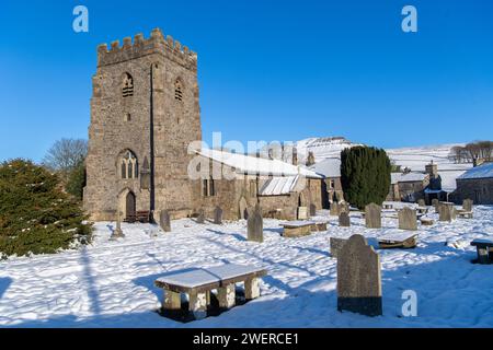 St. Oswald Parish Church in Horton in Ribblesdale mit Penyghent im Hintergrund an einem verschneiten Morgen. Yorkshire Dales National Park, Großbritannien. Stockfoto