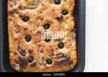 Blick von oben auf Oliven- und Zwiebelfokaccia auf weißem Hintergrund, Flatlay von Focaccia mit schwarzen Oliven und roten Zwiebeln, frisches hausgemachtes Focaccia-Brot Stockfoto